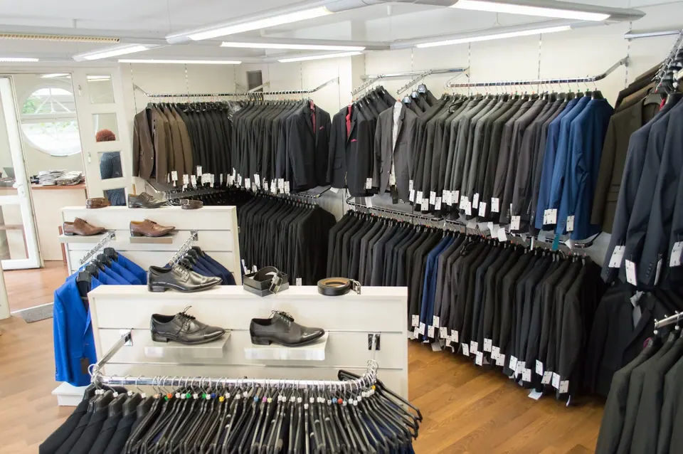 Az Elite Fashion Buda üzletbelső a Selmeci utcában: öltönyök és zakók hosszú sorai, cipők és övek
